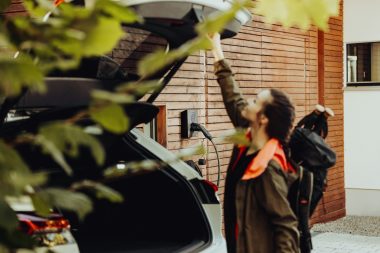 a man standing next to a parked car