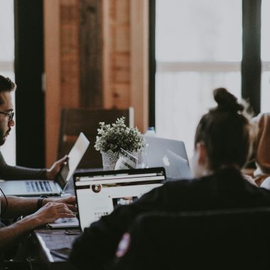 selective focus photography of people sits in front of table inside room