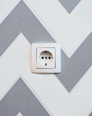 white power strip mounted on white and grey chevron painted wall
