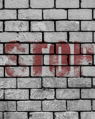Iemand bereidt een buitenmuur voor op het schilderen door het oppervlak te reinigen