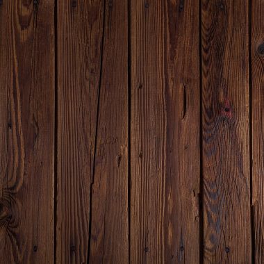 Landelijke woonkamer met houten balken, linnen kussens en aardewerken accessoires in warme, gedempte tinten