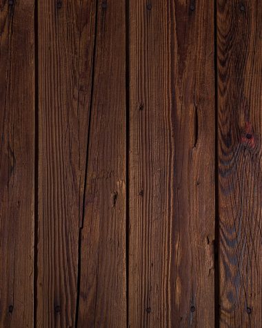 Landelijke woonkamer met houten balken, linnen kussens en aardewerken accessoires in warme, gedempte tinten