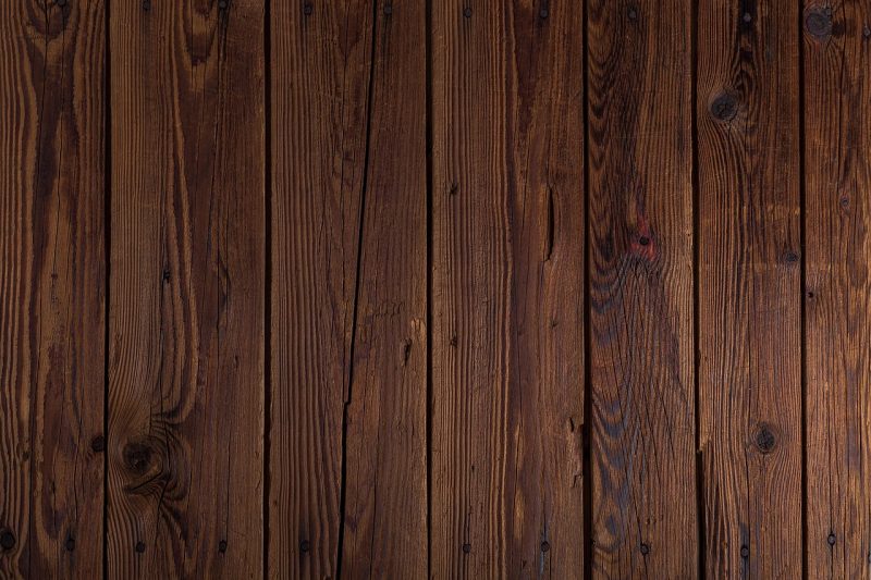 Landelijke woonkamer met houten balken, linnen kussens en aardewerken accessoires in warme, gedempte tinten