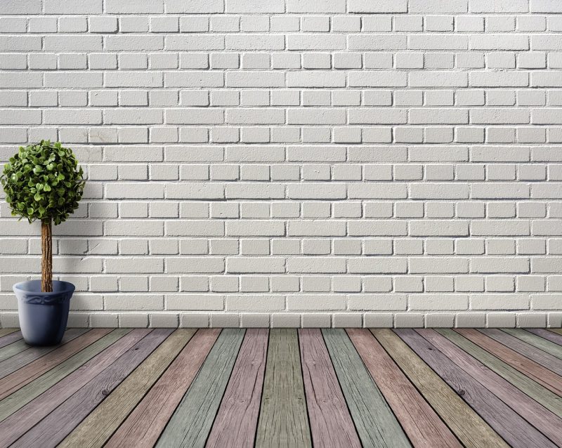 Witte muur in een woonkamer met zichtbaar warm licht dat de ondertoon van de verf benadrukt