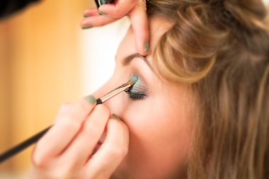 Vrouw die een bronzer aanbrengt op haar gezicht voor een stralende zomerlook