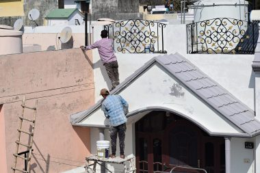 Persoon die een binnenmuur schildert met roller en kwast bij doe-het-zelf klussen