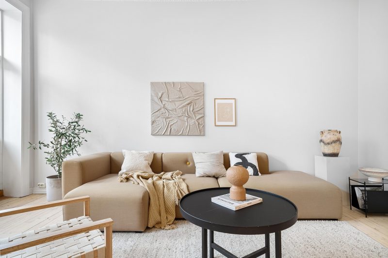 Designerkussen met jacquardpatroon op een linnen bank in een moderne woonkamer