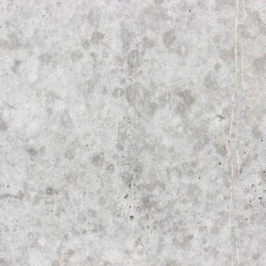 Drie grijze verfstalen in verschillende tinten op een witte muur, gefotografeerd met daglicht van opzij