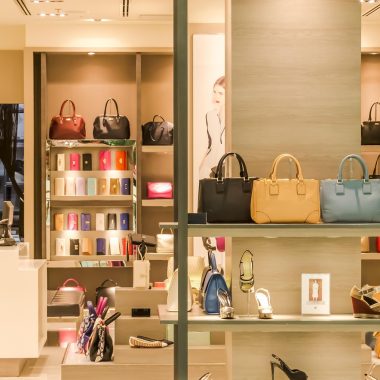Rekken met ribfluwelen kussens en aardewerken vazen in een Belgische woonwinkel