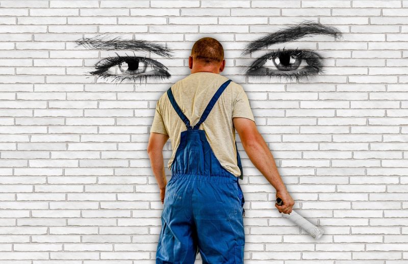 Iemand brengt muurverf aan op een muur met een verfroller